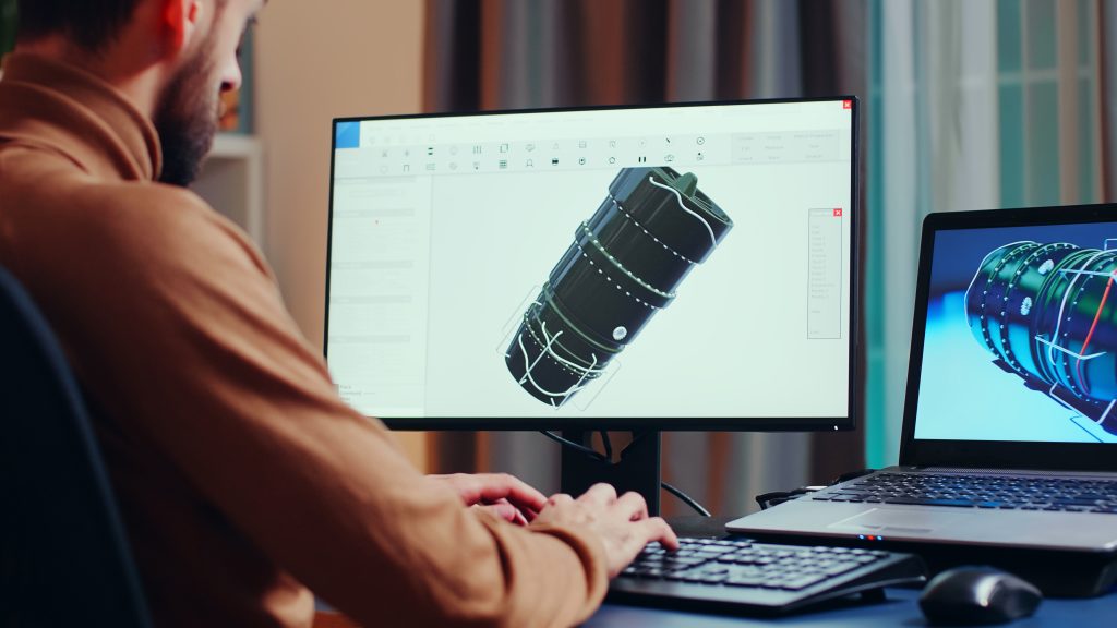 Young engineer looking closely at project on cad computer