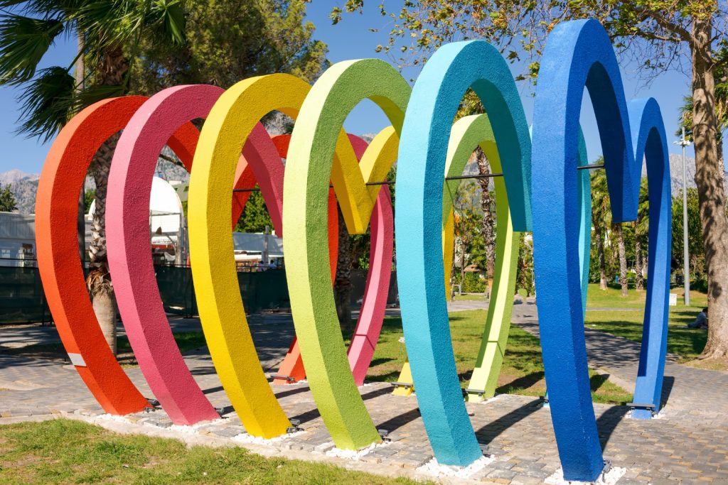 Multiple colorful arches forming a sculpture in a park.